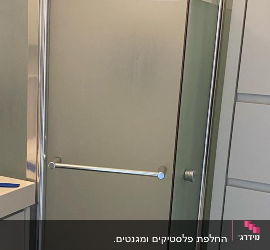 מקלחון זכוכית עם דלתות מתכת וברז מקלחת